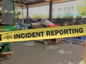 Security expert monitoring a real-time incident reporting dashboard with live video feeds, ensuring accurate documentation and response.
