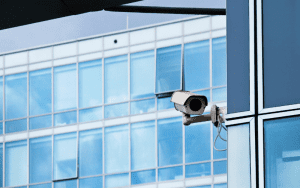 AI-powered security camera mounted on a modern office building, representing advanced surveillance solutions for commercial real estate. Smart surveillance and live security monitoring help prevent unauthorized access and enhance office building security.