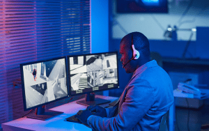 Security operations center agent monitoring live surveillance camera feeds to detect intrusions and respond in real time with proactive video monitoring solutions.